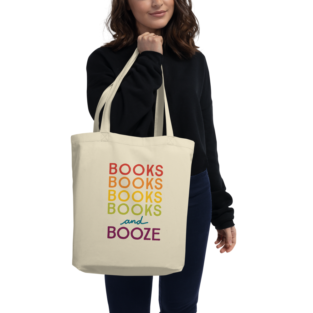 Woman holding a Cotton Tote Bag with the words "Books Books Books Books and Booze" on it